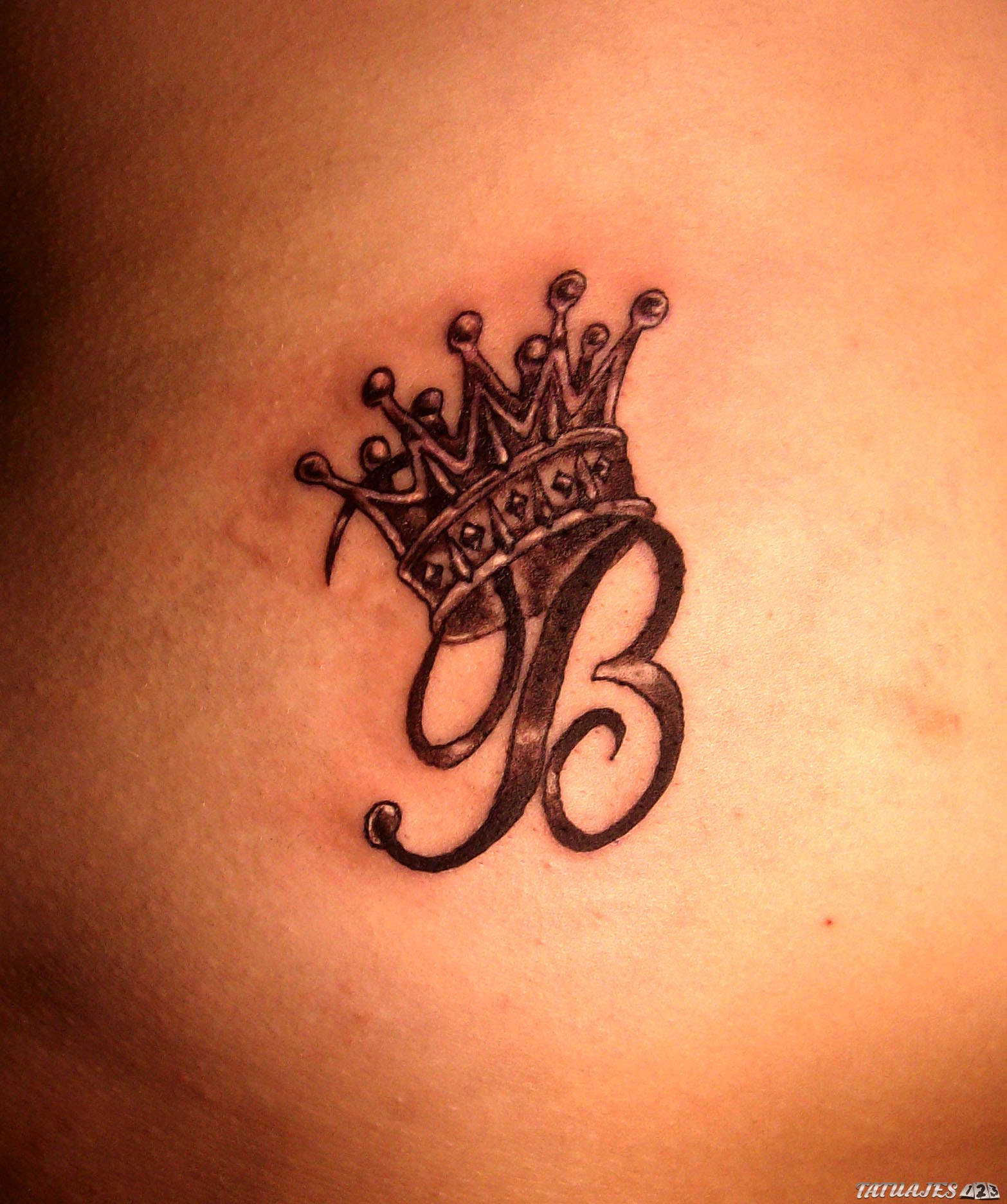 tatuaje corona con inicial