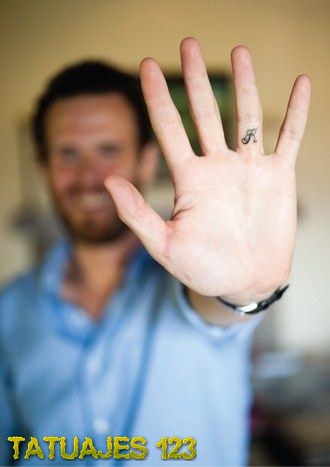 Tatuaje de inicial en el dedo